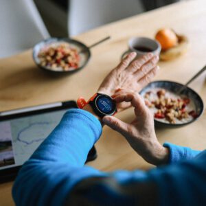 Smartwatch and breakfast on wooden table