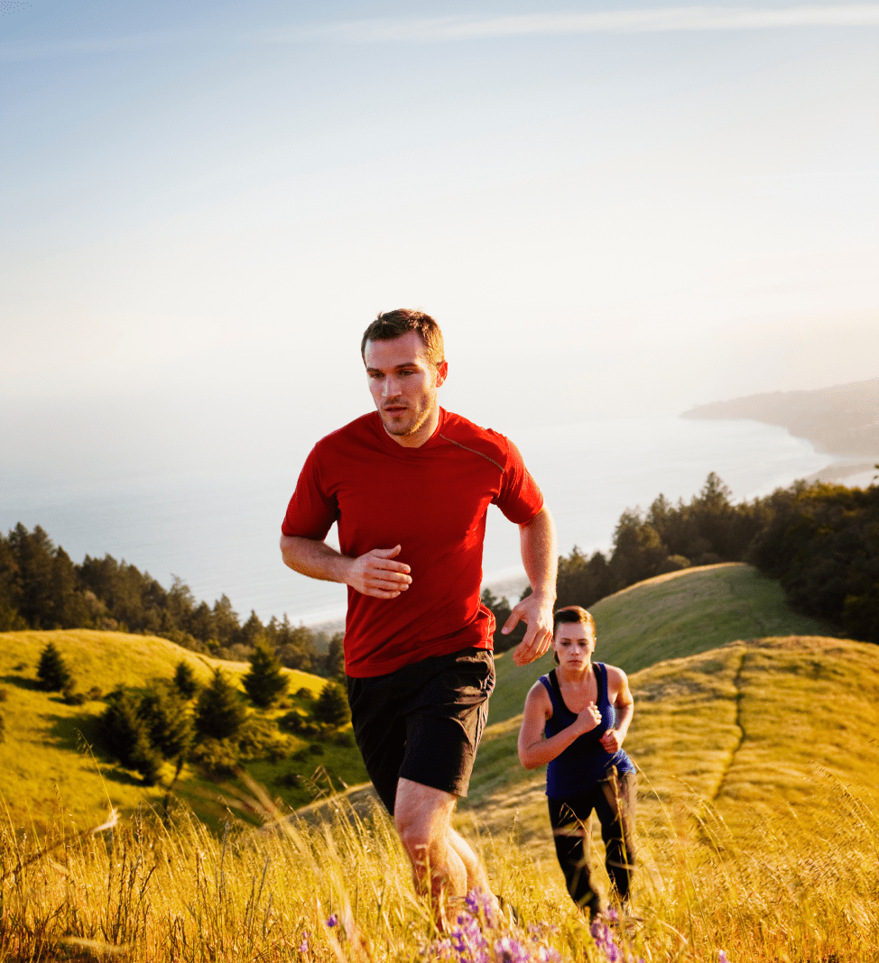 Trail runners on a sunny hillside