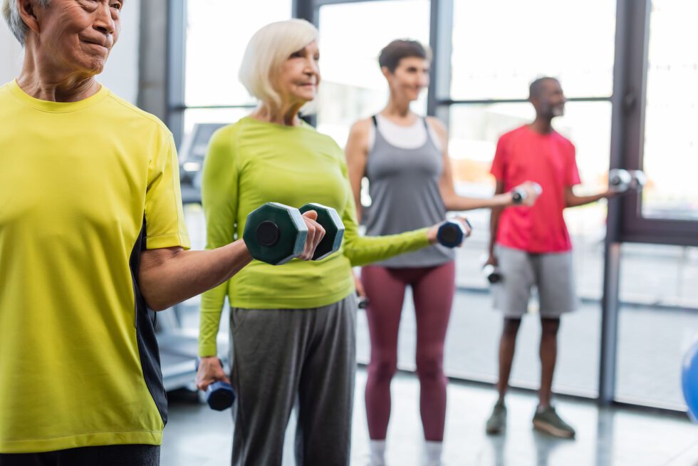Group exercising with dumbbells indoors