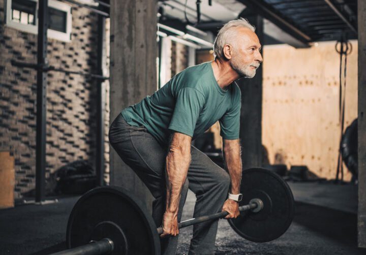 Older man performing deadlift exercise