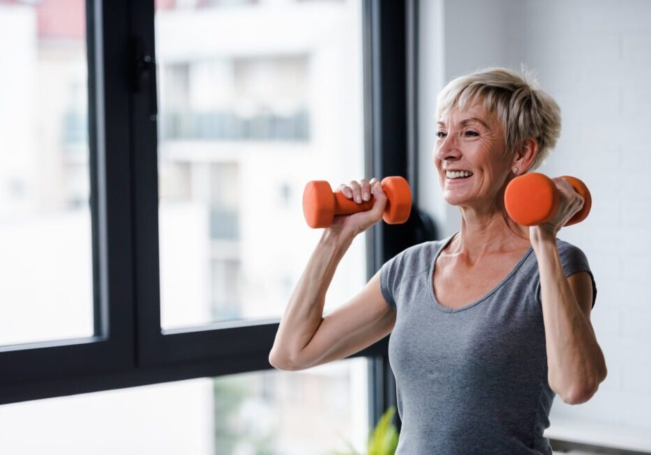 Woman exercising with dumbbells indoors