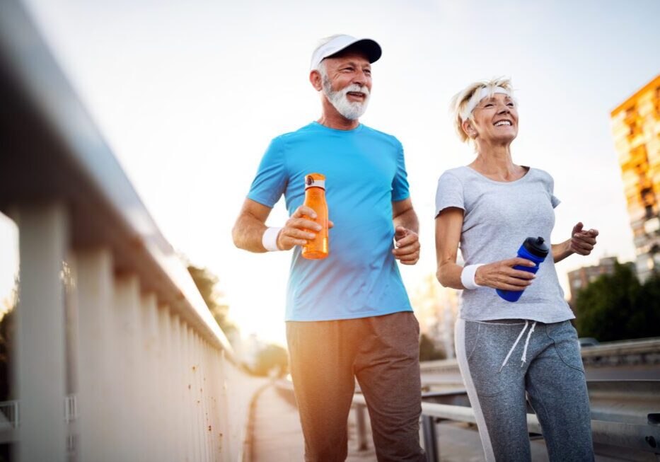 Seniors exercising outdoors with smiles