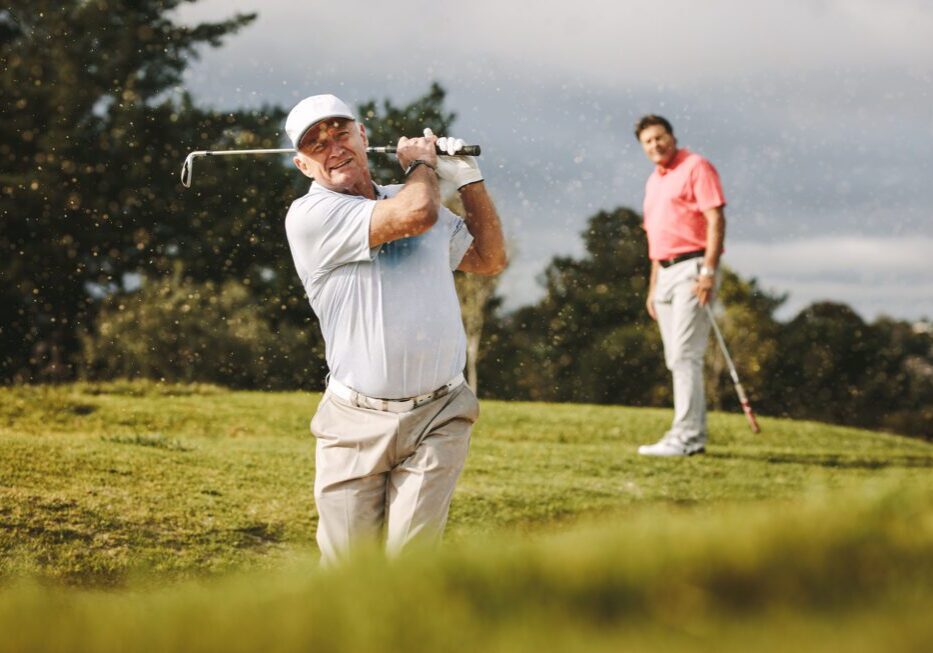 Two men playing golf on course