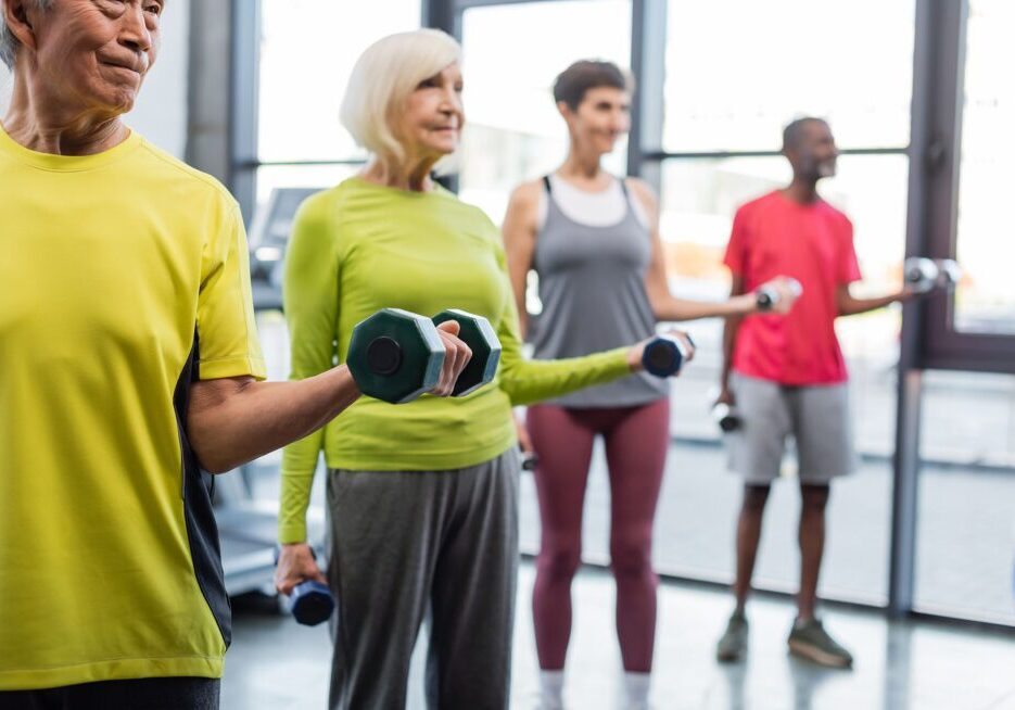 Group exercising with dumbbells indoors