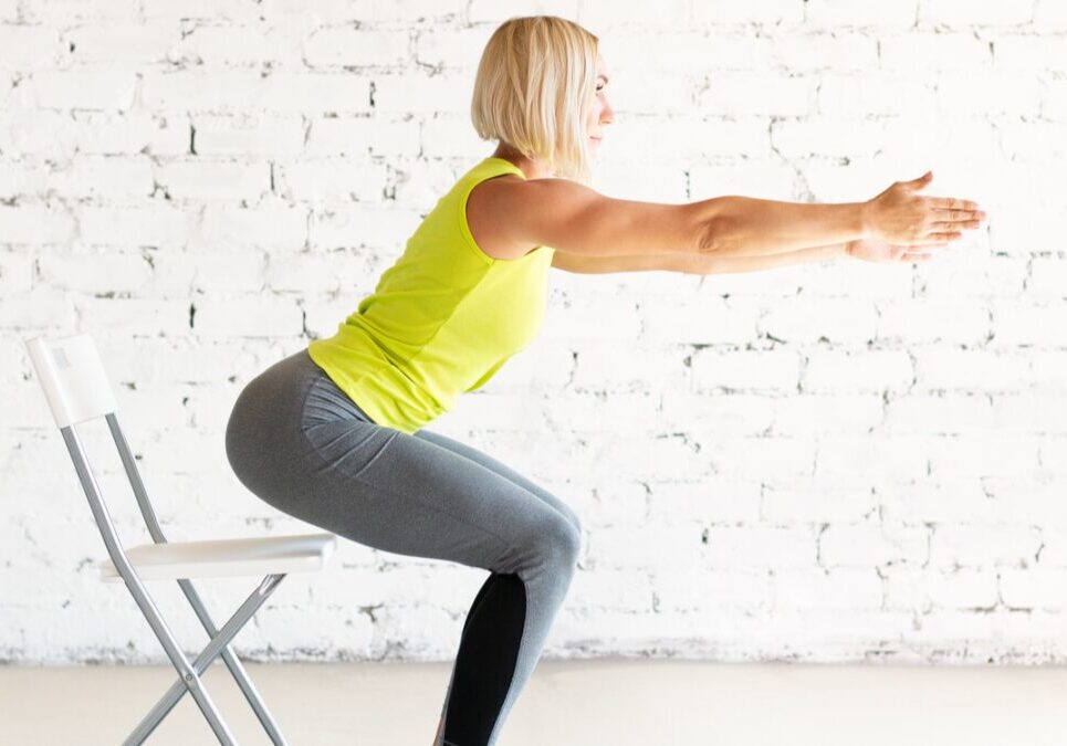 Woman practicing chair squats indoors